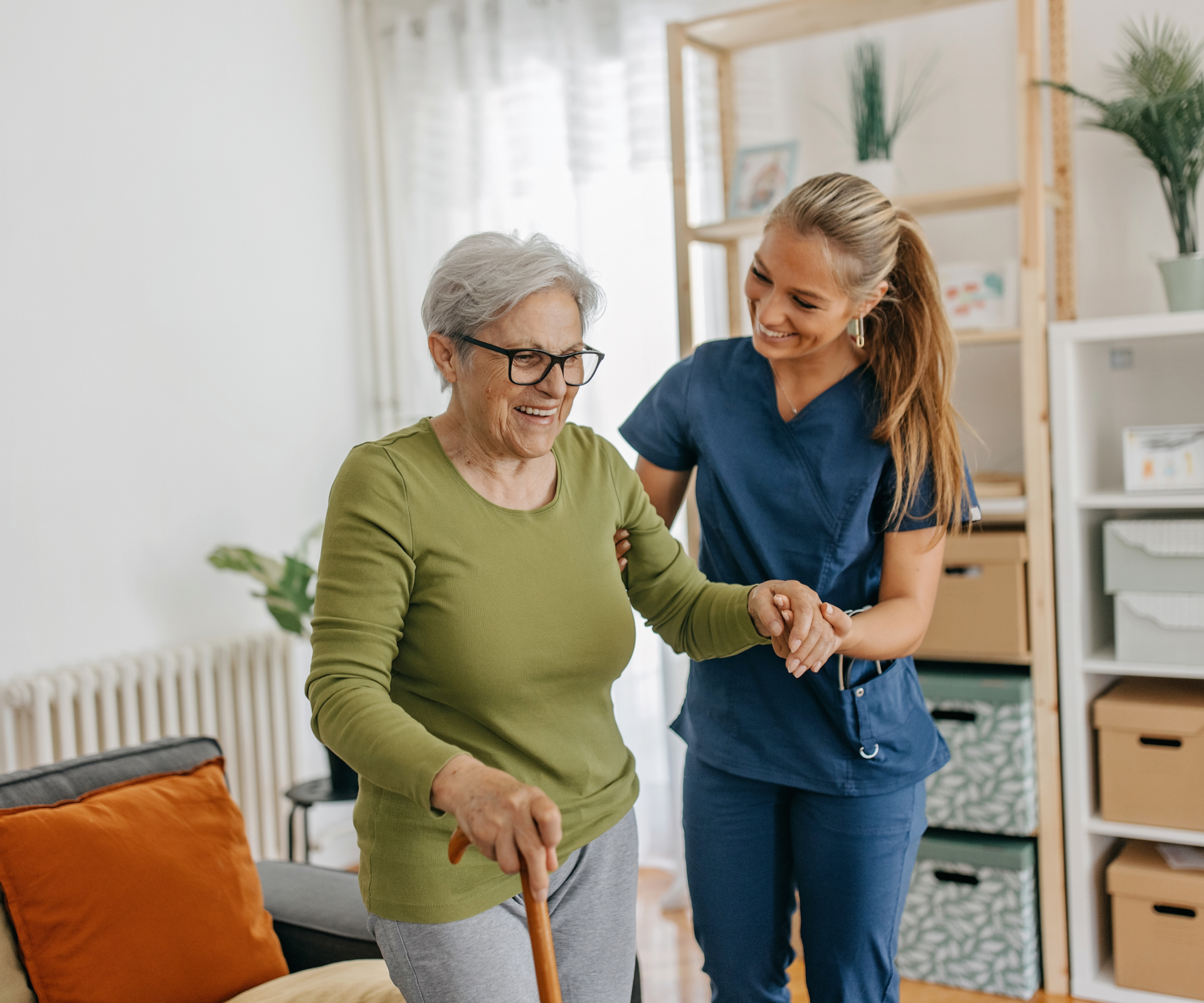 Caregiver supporting elderly woman's mobility